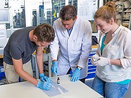 Studierende kleben mit Prof. Dr.-Ing. Tim Jüntgen 