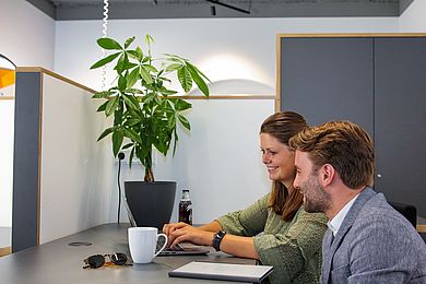 Zwei Menschen sitzen an einem Arbeitsplatz