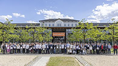 Gruppenfoto mit den Absolventinnen und Absolventen auf dem Campus