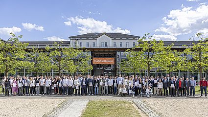 Gruppenfoto mit den Absolventinnen und Absolventen auf dem Campus