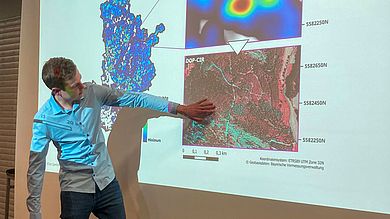 Kilian Sperber vor einer Leinwand bei seinem Vortrag