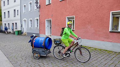 Professor Weiß auf dem Fahrrad mit Anhänger