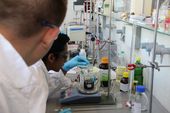 Student füllt Flüssigkeit in einen Messbecher im Labor Verfahrenstechnik