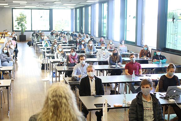 Studienanfänger sitzen mit Abstand