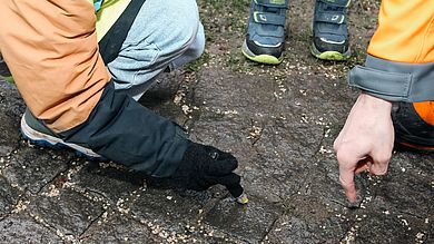 Kind malt Kreuz mit Kreide