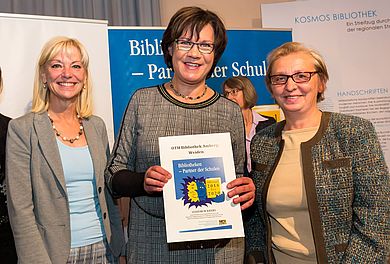 Christina Michel, Leiterin der Bibliothek der OTH Amberg-Weiden, hält die Urkunde, links von ihr Carolina Trautner und rechts neben ihr steht Monika Patuska