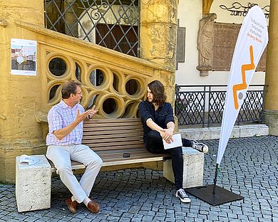 Junger Mann sitzt bei Professor Späte auf der Bank