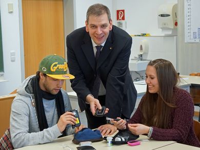Dr. Thomas Egginger, Ärztlicher Direktor der Kliniken Nordoberpfalz AG, mit zwei Studierenden bei der Blutzucker-Messung