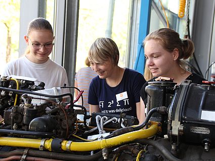 Schülerinnen schauen Motor an