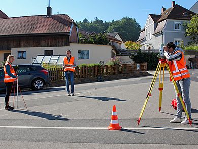 drei Studierende vermessen Kreuzung