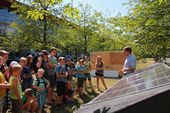 Der Laborleiter zeigt einer Schulklasse eine Photovoltaik-Anlage.