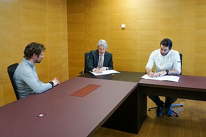 Drei Personen sitzen an einem Tisch