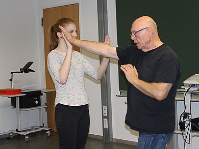 Studentin wehrt einen Angriff von Klaus Inderst ab