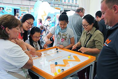 Messebesucherinnen und -besucher beim Kreiselgewinnspiel.