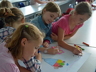 Teamwork: Schülerinnen zeichnen einen Plakatentwurf.