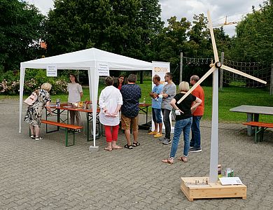 Menschen informieren sich an einem Infostand über Windkraft