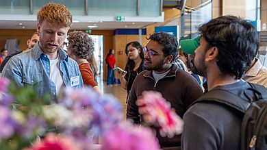 Zwei Studierende sprechen mit Firmenvertreter