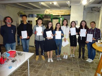 Chinesische Studierende halten ihre Zertifikate in der Hand