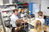 Professor erklärt den Studenten eine Maschine im Labor für Kunststofftechnik. 