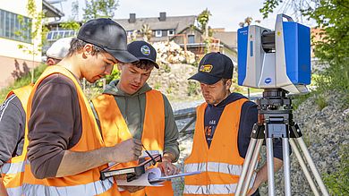 Studierende an einem Messgerät und notieren Messdaten