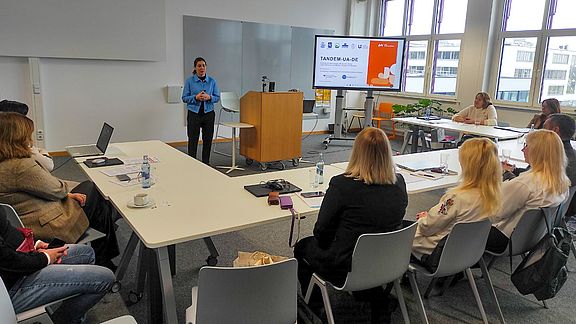 Teilnehmer sitzen an Tischen