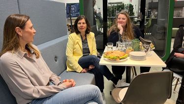 drei Frauen sitzen um einen Tisch