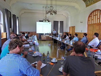 Teilnehmer im Senatssaal hören Georg Funk zu