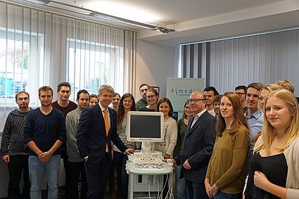 Spendenübergabe: Prof. Dr. Clemens Bulitta (links vom Gerät) und 4medic-Gründer Heribert Pfaffl (rechts vom Gerät) mit Medizintechnik-Studierenden.