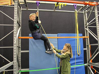 Schüler sieht sich am Seil nach oben