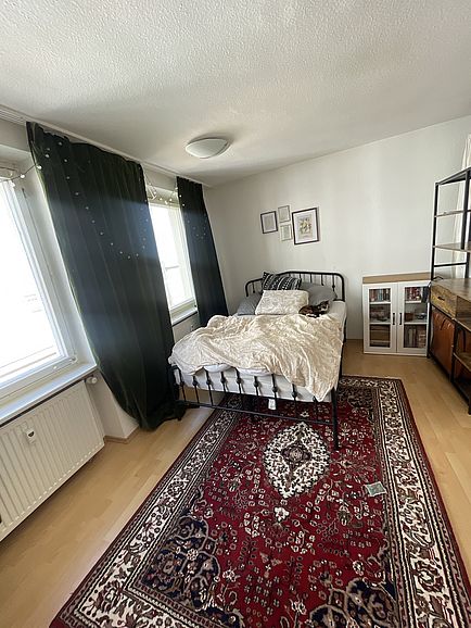 Zimmer mit Bett und teppich 