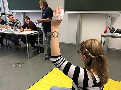 Studentin hält verbundenen Finger nach oben