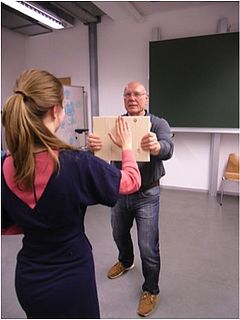 Mit der Hand eine Massivholzplatte in der Luft durchschlagen