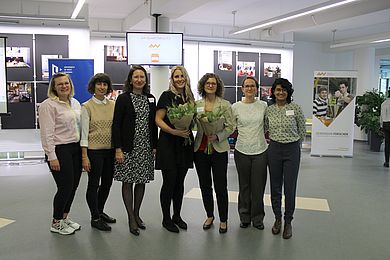 Gruppenbild von siebem Frauen, zwei haben einen Blumenstrauß in den Händen 