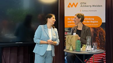 Zwei Frauen an Stehtisch im Gespräch