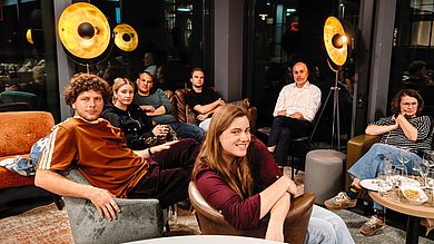 Gruppe Menschen sitzend in der Orange Lounge