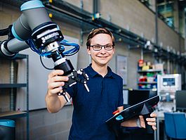Student am kol­la­bo­rie­renden Roboter