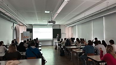 Personen sitzen in einem Klassenzimmer