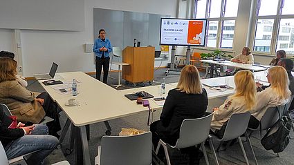 Teilnehmer sitzen an Tischen