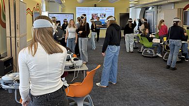Voller Einsatz im digitalen Klassenzimmer der OTH Amberg-Weiden: In dem modern ausgestatteten Lernraum zahlreichen Bildschirmstationen legen die Schülerinnen die Apple Vision Pro an und tauchen in die virtuelle Anatomie ein.
