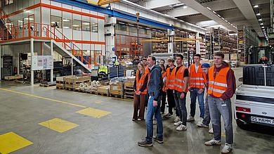 Sicher ausgestattet in Warnwesten erkunden die Teilnehmenden die industrielle Fertigung mit besonderem Augenmerk auf die Einbindung von SAP S/4 HANA an den jeweiligen Arbeitsplätzen