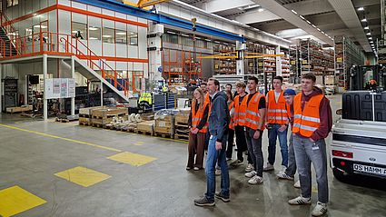 Sicher ausgestattet in Warnwesten erkunden die Teilnehmenden die industrielle Fertigung mit besonderem Augenmerk auf die Einbindung von SAP S/4 HANA an den jeweiligen Arbeitsplätzen