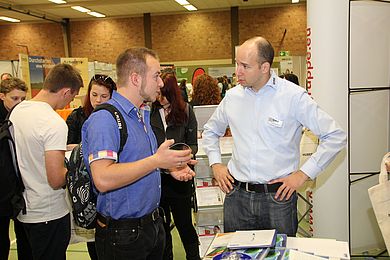 Student im Gespräch mit Unternehmensvertreter
