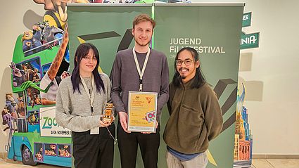 Studierende halten Auszeichnung in der Hand