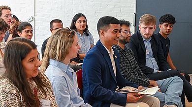 Nikil mit anderen Studiereden während der Diskussion