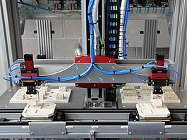 Automatisierungstechnik Maschine mit zwei Greifarmen zum Umsetzen von Bauklötzen