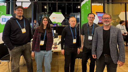 Medien-Team vor dem Messestand