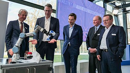 Ein Roboter übergibt den Schlüssel zur offiziellen Eröffnung des TTZ NEW an Staatsminister Blume