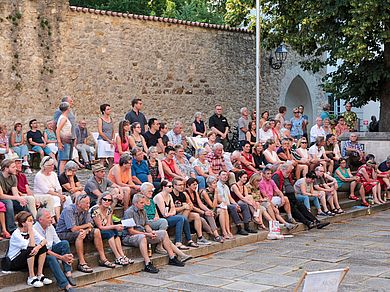Publikum sitzt auf den Stufen