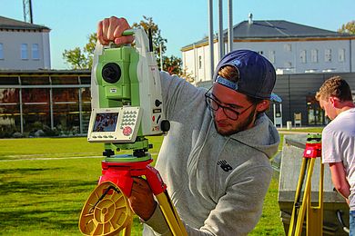 Student steht an einem Tachymeter