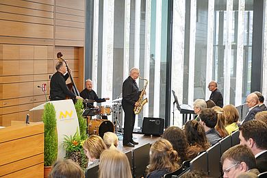 Eine Band spielt vor Leuten in einem Hörsaal